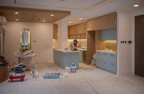 New kitchen units being installed in a stripped-out room
